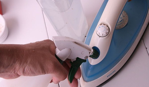 Dùng nước sạch (hoặc nước cất) và dấm trong bình chứa nước bàn ủi
